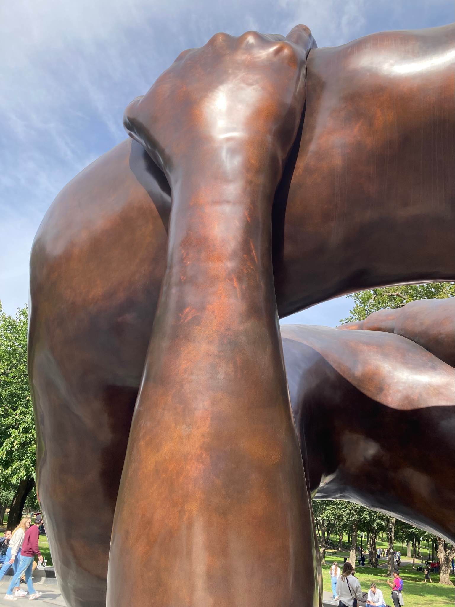 Photo of a huge bronze statue titled "The Embrace" honoring Martin Luther King, Jr. and Coretta Scott King, located on Boston Common on a sunny blue-sky day.